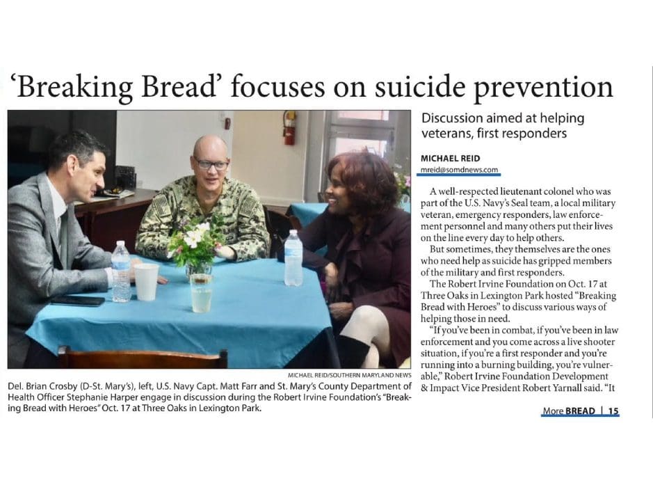 A group of people engage in a discussion at a table with water bottles and papers. The text highlights a suicide prevention discussion for military and emergency personnel.