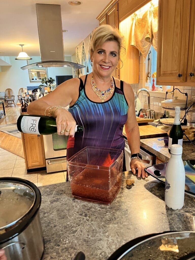 Woman pouring wine into a blender in a kitchen.