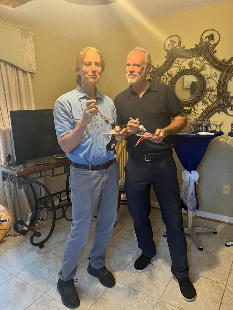 Two men holding model airplanes indoors.
