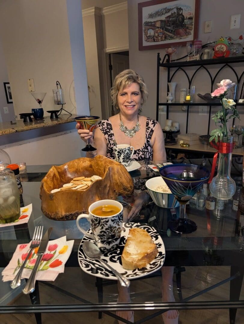 Woman enjoying tea with pastries in a cozy setting.