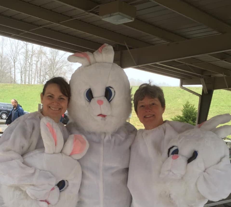 Three people in bunny costumes outdoors.