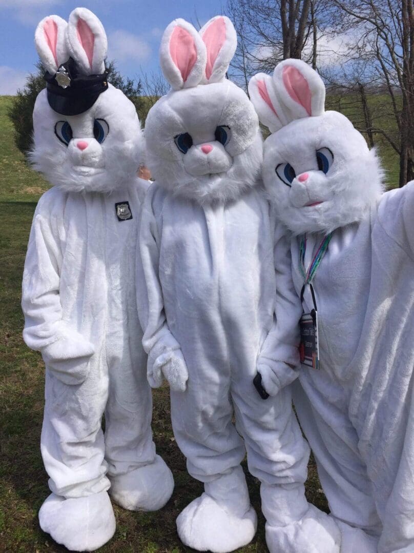 Three people in white bunny costumes.